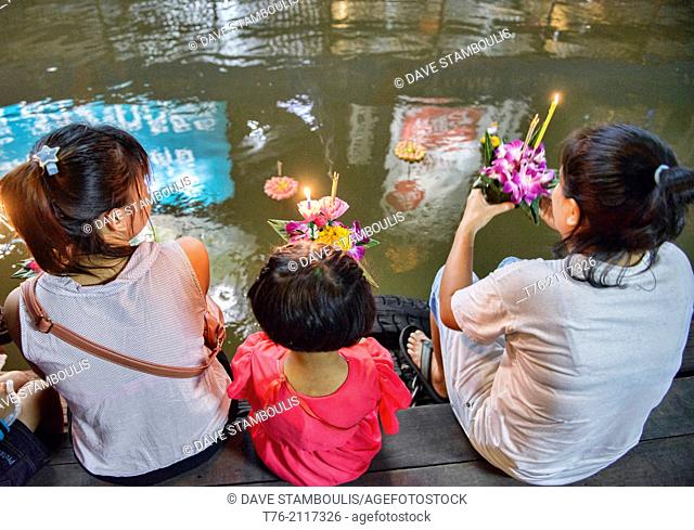 Friends gather to release floating offerings during Loy Kratong festival in Bangkok, Thailand