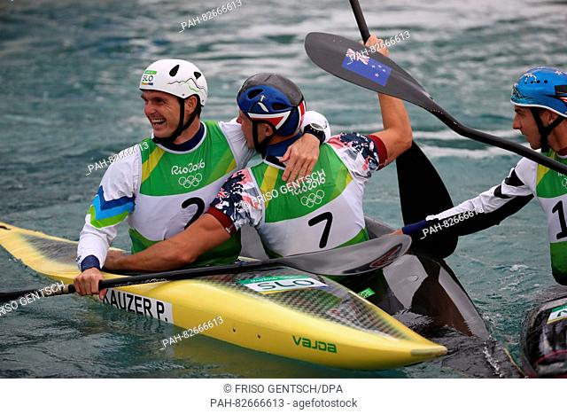 Winner Joseph Clarke of Great Britain (C) celebrates with Second placed Peter Kauzer (L) of Slovenia and Mike Dawson (R) of New Zealand after the Kayak (K1) Men...