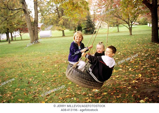 Children on tire swing. USA