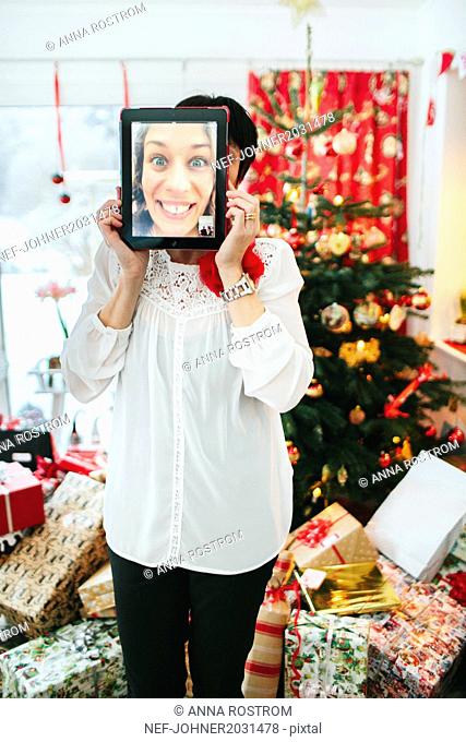 Woman with digital tablet in front of her face