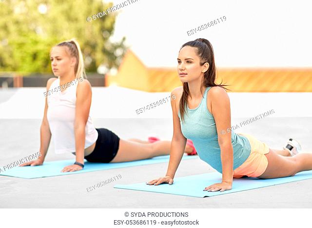 women doing sports on exercise mats outdoors