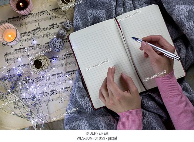 Hands of woman writing in notebook