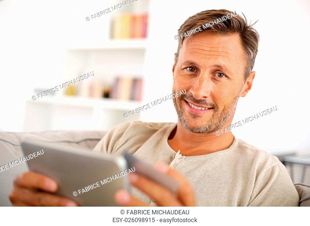 Handsome smiling man at home buying on internet