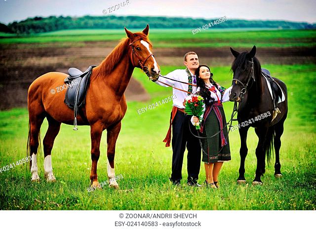 Young couple on national dress with horses