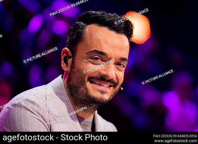 26 March 2022, North Rhine-Westphalia, Cologne: Giovanni Zarrella from the guessing team sits at the guessing desk in the Prosieben show ""The Masked Singer""