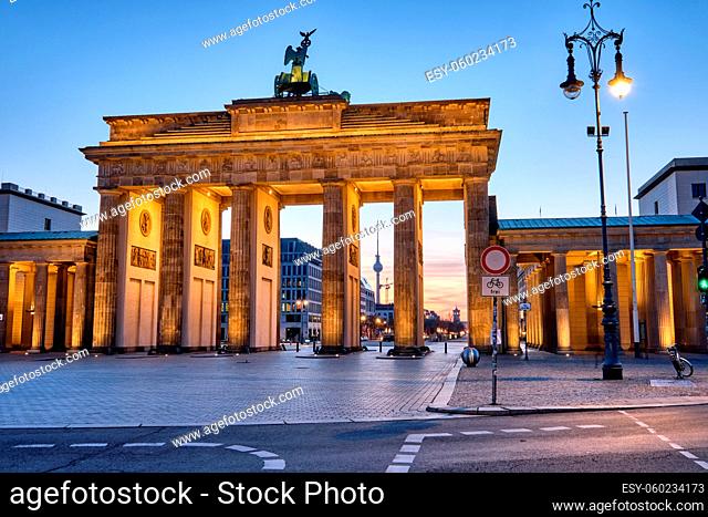 Das Brandenburger Tor mit dem Fernsehturm im Hintergrund in der Dämmerung, gesehen in Berlin, Deutschland