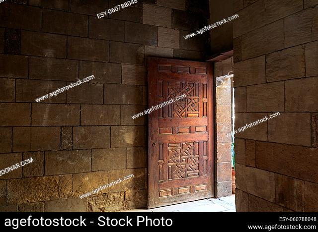 Old abandoned room with stone bricks and grunge weathered wooden decorated door, Old Cairo, Egypt
