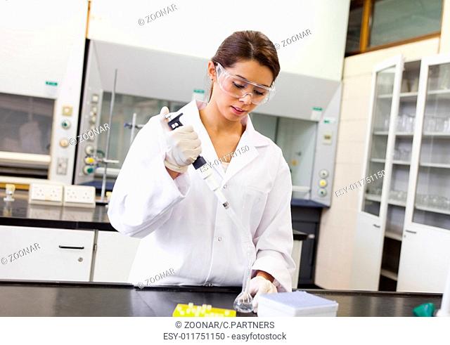 Scientist pouring a liquid in an Erlenmeyer flask