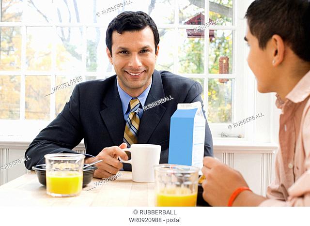 Man and boy at breakfast table displeased