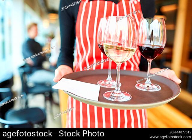 Bedienung trägt Gläser mit Wein auf einem Tablett im Bistro oder Restaurant
