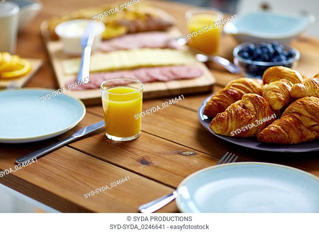 plate of croissants on wooden table at breakfast