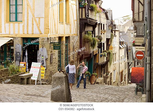 Couple taking pictures. Jerzual cobbled street. Dinan. Britanny. France