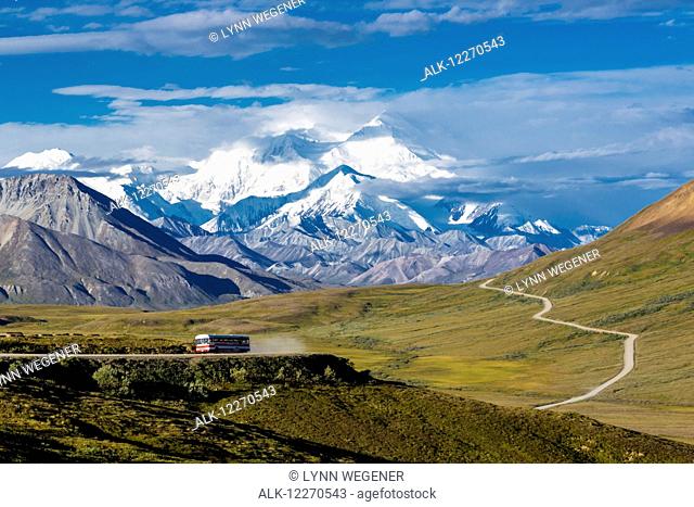 Scenic view of Mt. McKinley and Thorofare Pass with a tourist lodge bus in the foreground in Denali National Park, Interior Alaska, Summer, USA