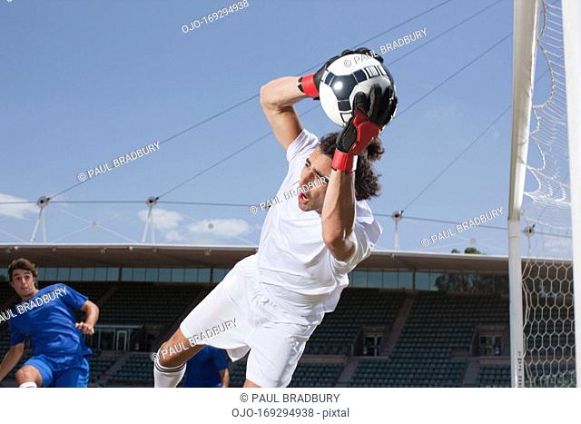 Soccer goalie catching soccer ball