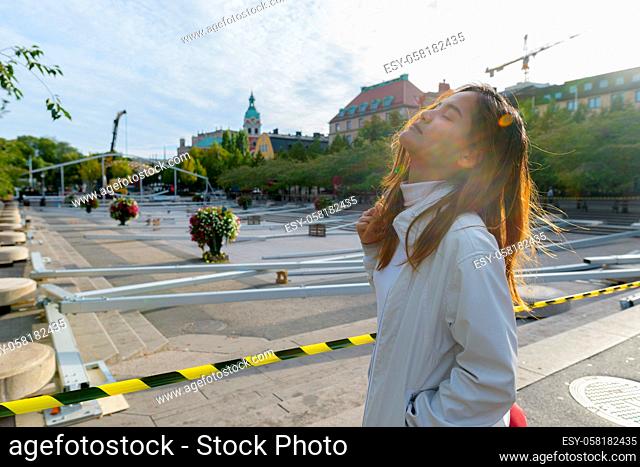 Portrait of young beautiful Asian tourist woman traveling around the city of Stockholm in Sweden