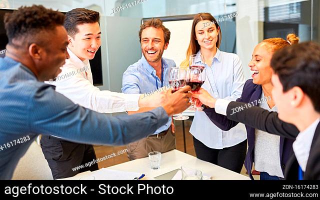 Fröhliche Business Leute feiern einen Erfolg mit einem Glas Rotwein im Büro