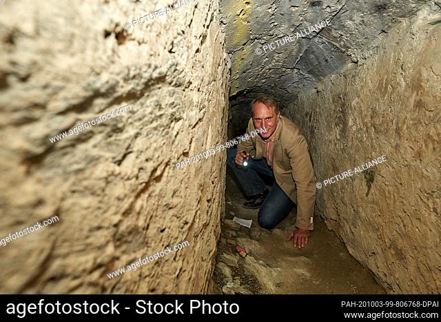 02 October 2020, Rhineland-Palatinate, St. Goar: St. Goars town mayor Falko Hanisch crawls through one of the corridors under Burg Rheinfels