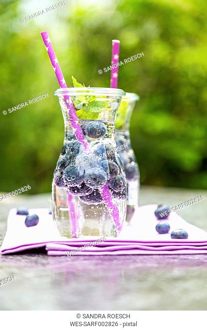 Two carafes of infused water with blueberries and mint