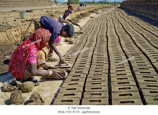 Indian family forming bricks made from mud clay at Khore Bricks Factory, Rajasthan, Northern India