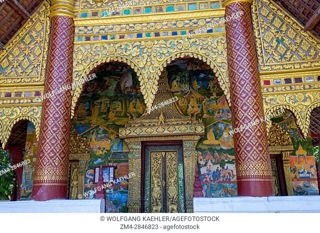 Detail with frescoes and door of Wat Xieng Muan (Xieng Muan Vajiramangalaram) a Buddhist temple in the UNESCO world heritage town of Luang Prabang in Central...