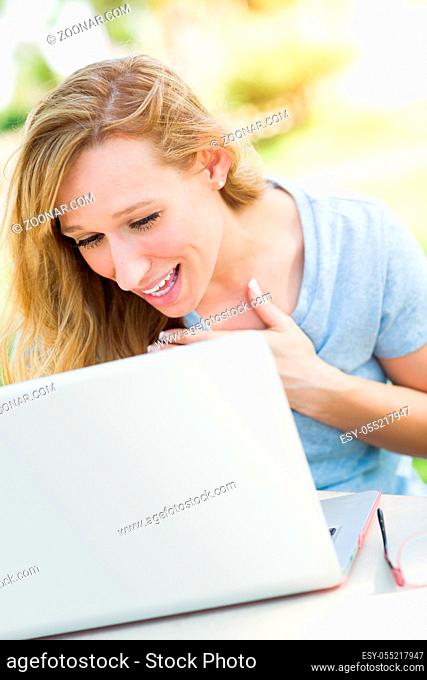 Young Adult Woman Live Video Chatting Outdoors Using Her Laptop