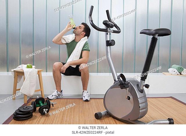 Man drinking sports drink in home gym