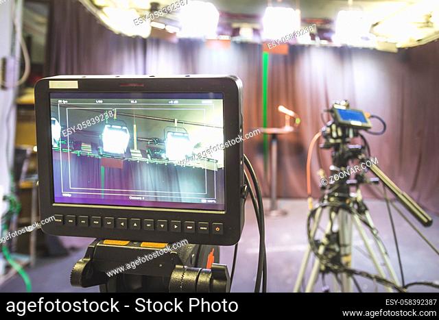 Film camera on a tripod in a television broadcasting studio, spotlights and equipment