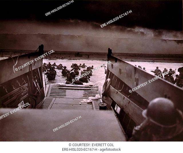 American soldiers wade from Coast Guard landing craft toward the Omaha Beach against machine gun fire on D-Day. June 6, 1944, by Coast Guard photographer