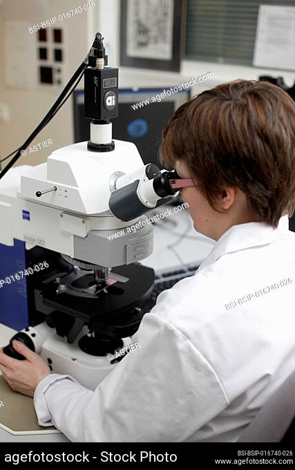 Cytogenetics laboratory, technician carrying out a prenatal diagnosis by medical imaging FISH (Fluorescent In Situ Hybridization / Hybridization par...