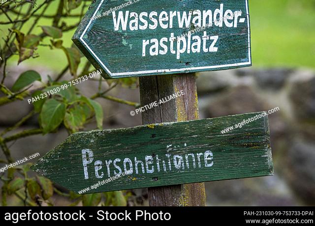 PRODUCTION - 26 October 2023, Mecklenburg-Western Pomerania, Stolpe: The wooden signpost shows the direction to the small passenger ferry across the Peene