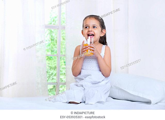 Cute little girl drinking juice