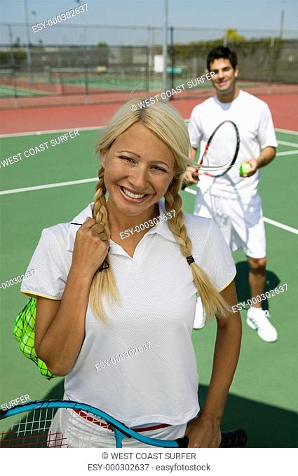 Female tennis player standing on tennis court portrait