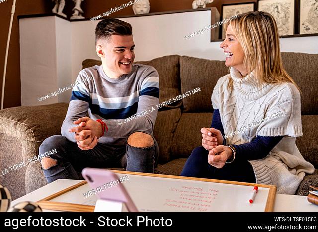 Female counselor and young man laughing during motivation session at work place