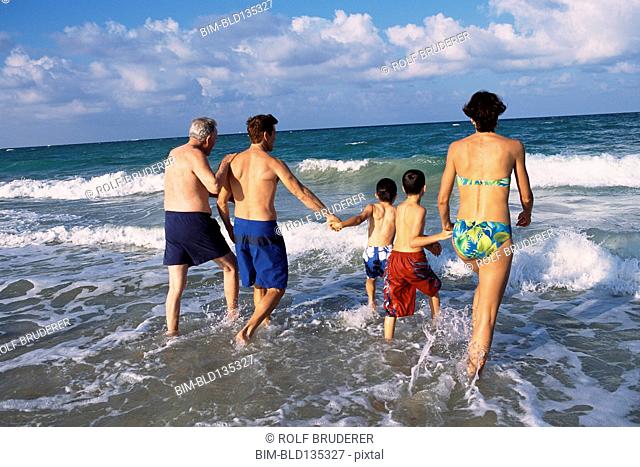 Family walking in waves on beach
