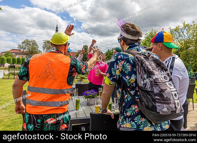 18 May 2023, Brandenburg, Neuzelle: Young men celebrate on Ascension Day in a restaurant at the Neuzelle Monastery. Ascension Day is a church holiday celebrated...