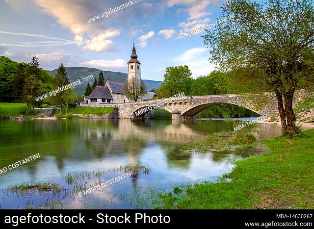 Church of St. John the Baptist and the stone bridge by the Bohinj lake at sunset. Bohinj lake, Slovenia, Europe