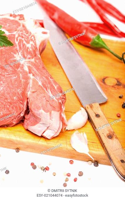 fresh meat of beef with bone on wooden spices and knife