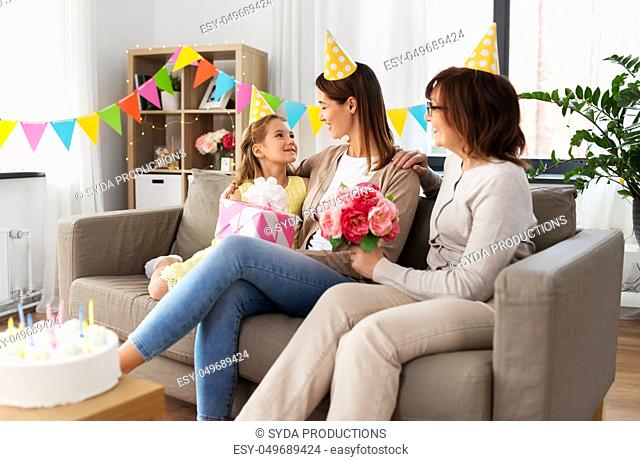 daughter with gift box greeting mother on birthday