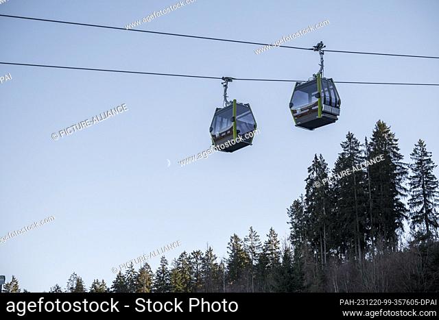 PRODUCTION - 18 December 2023, Bavaria, Bischofsgrün: Two gondolas of the new 10-passenger single-cable gondola lift travel from the valley station north to the...