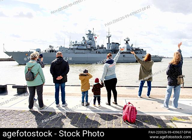 26 May 2022, Lower Saxony, Wilhelmshaven: Members of the crew wave goodbye as the Navy frigate ""Mecklenburg-Vorpommern"" leaves the harbor at the naval base