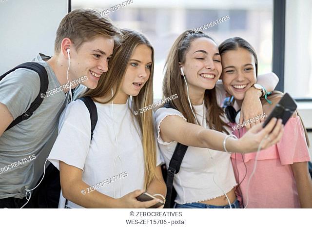 Happy students taking a selfie in school