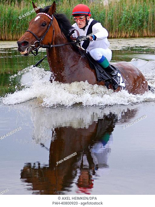 Vlastislav Korytar on Indian Sun, winner of the lake hunt race (Seejagdrennen), leads at the water hurdle during the equine sports gallop derby meeting at...