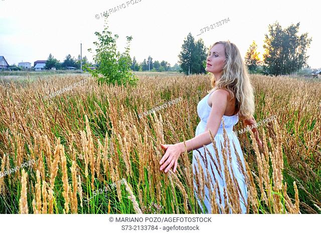 Young woman in a wheat field in a russian village, Kirillovka, Russian Federation