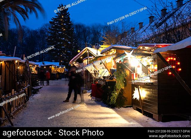 08 December 2023, Saxony, Königstein: The stalls at the Christmas market at Königstein Fortress are brightly lit (shot with long exposure)