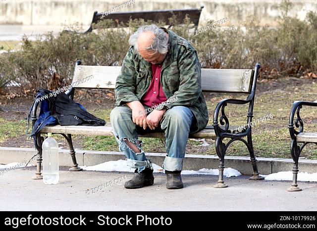 A homeless man is sitting and sleeping on a bench in a park in Bulgaria's capital Sofia. Years after joining the EU the country is still struggling with great...