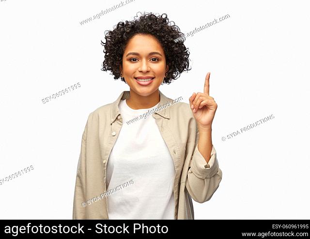 portrait of smiling woman pointing finger up