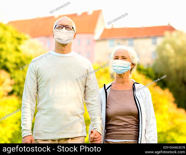 senior couple in protective medical masks outdoors