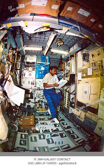 Astronaut Michael P. Anderson, STS-107 payload commander, reads a procedures checklist while working at the Combustion Module (CM-2) in the SPACEHAB Research...