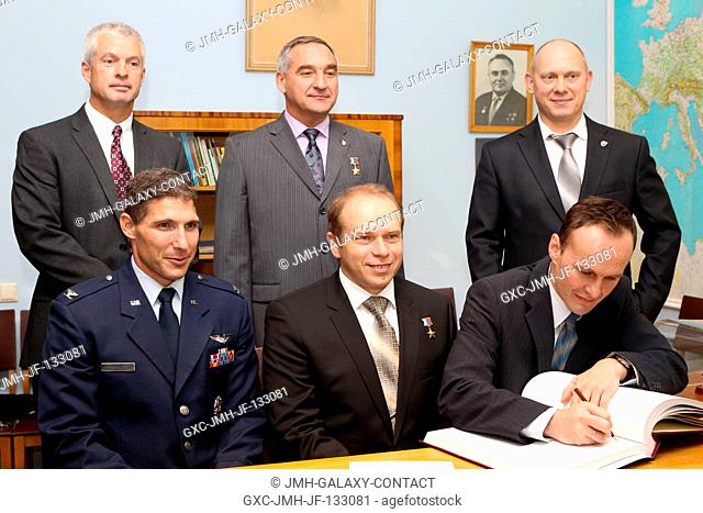At the Gagarin Cosmonaut Training Center in Star City, Russia, Expedition 3738 Flight Engineer Sergey Ryazanskiy (right, front row) signs a certification book...