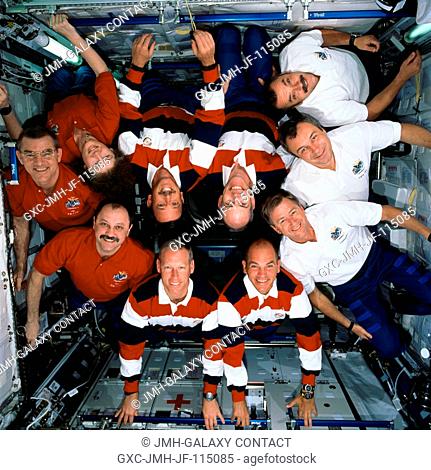 The Expedition Three (white shirts), STS-105 (striped shirts), and Expedition Two (red shirts) crews assemble for this in-flight group portrait in the Destiny...
